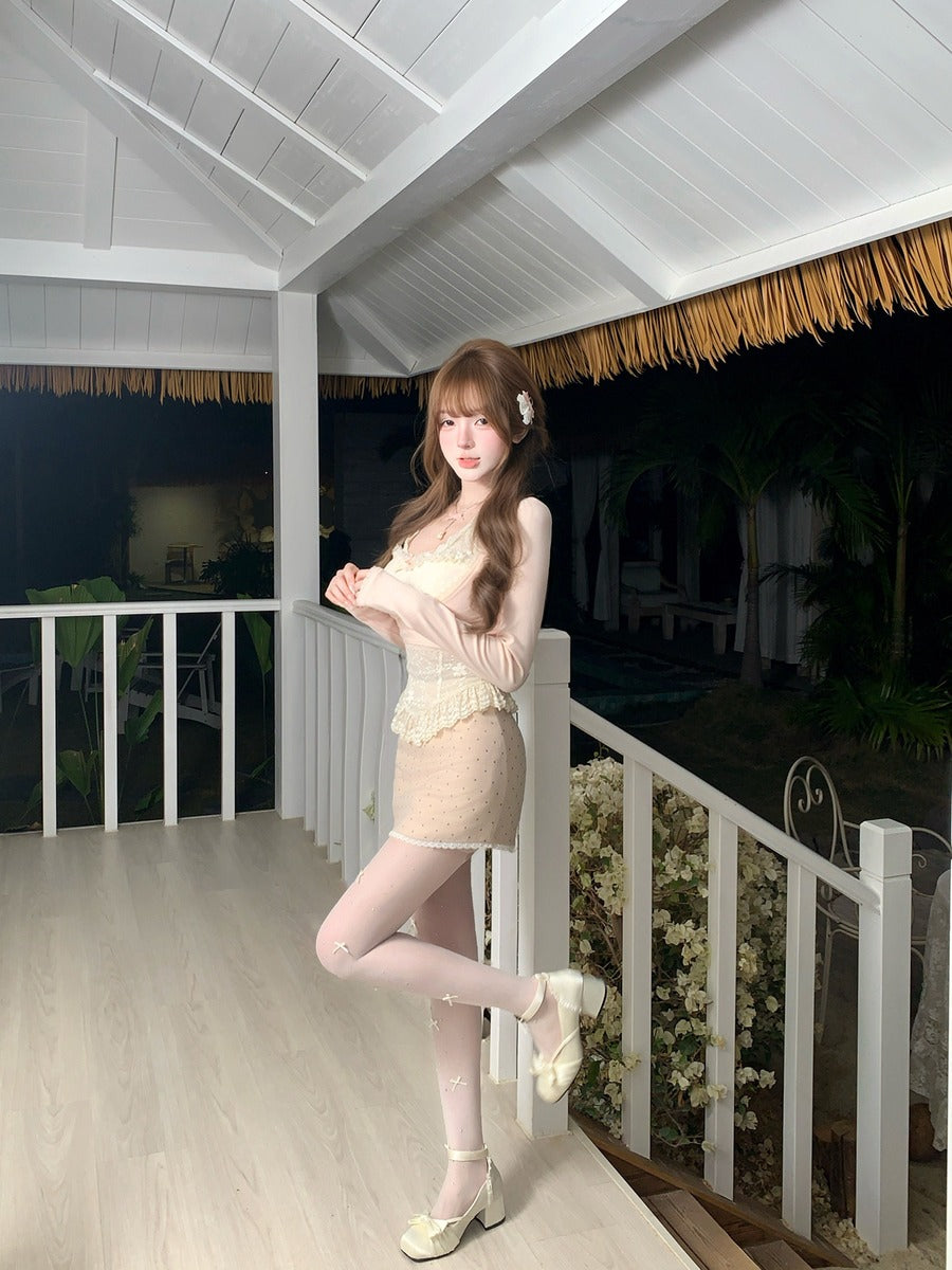 Woman in a beige dress standing on a balcony with white railing and wooden floor.