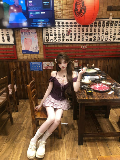 Woman sitting at a table in a restaurant with a TV screen displaying a game in the background.