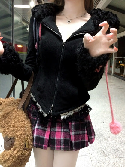 Person wearing a black jacket with fur trim and a plaid skirt, holding a teddy bear.