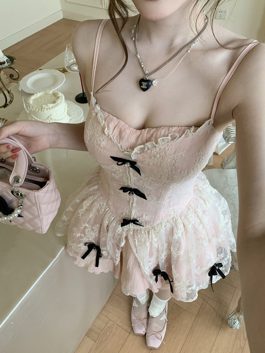 Person wearing a pink lace dress with black bows in a bathroom setting.