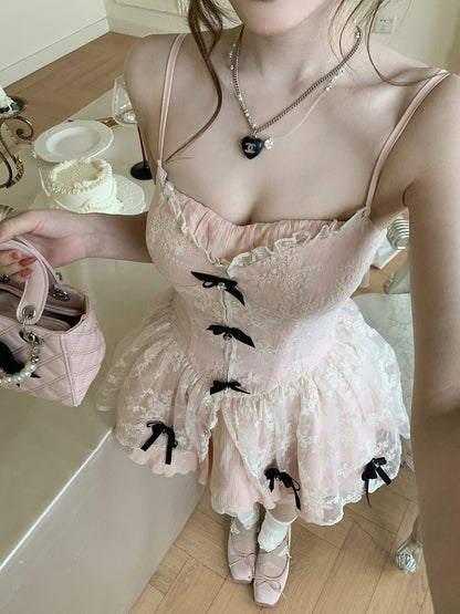 Person wearing a pink lace dress with black bows in a bathroom setting.