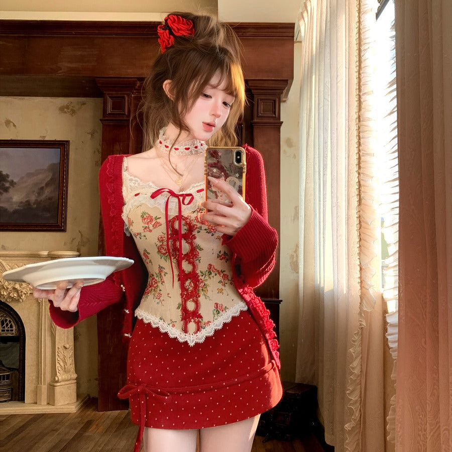 Woman in a red and white outfit taking a mirror selfie in a room with wooden floor and fireplace.