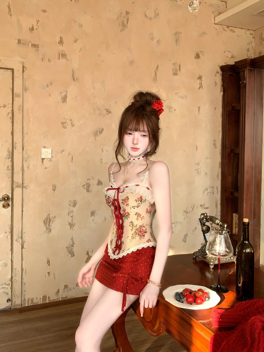 Woman in a floral top and red shorts standing in a room with patterned wallpaper.