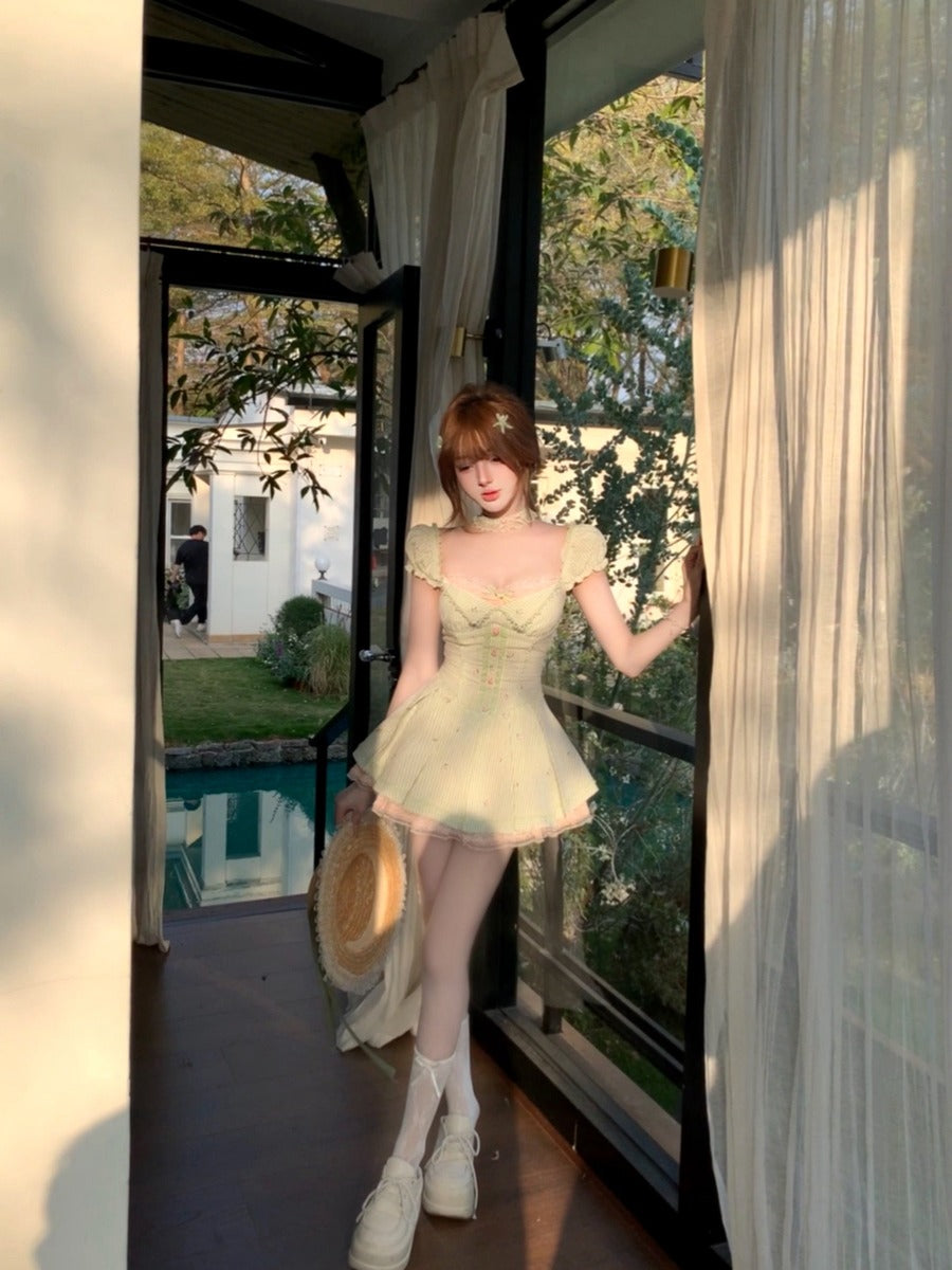 Woman in a light green dress standing in a doorway with a garden view.