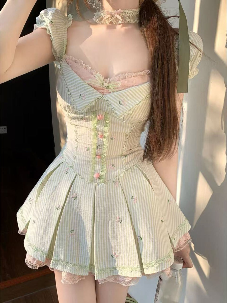 Person wearing a light-colored, lace-trimmed dress with a floral pattern.