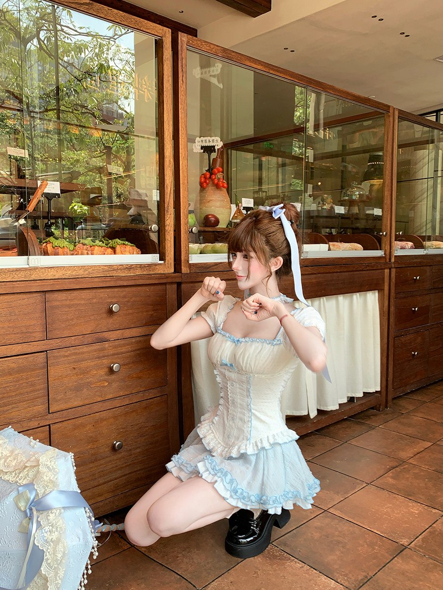 Person in a maid outfit posing in a restaurant kitchen.