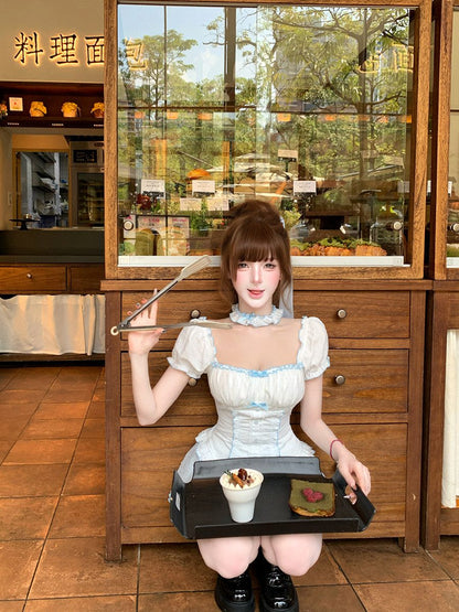 Woman in a white dress holding a tray with food in a restaurant setting