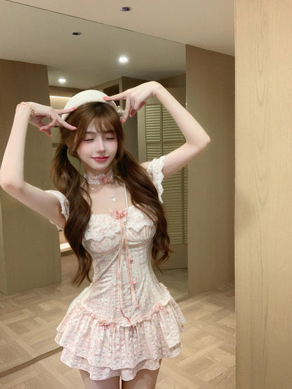 Woman in a white lace dress posing in front of a mirror.