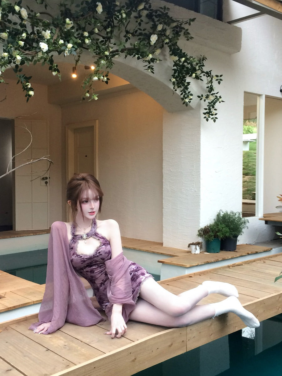 Woman in a purple dress sitting by a pool with decorative plants and flowers.
