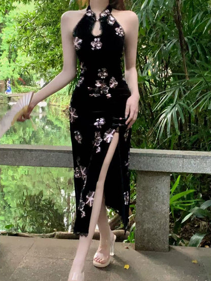 Woman wearing a black floral dress with a high slit in a garden setting