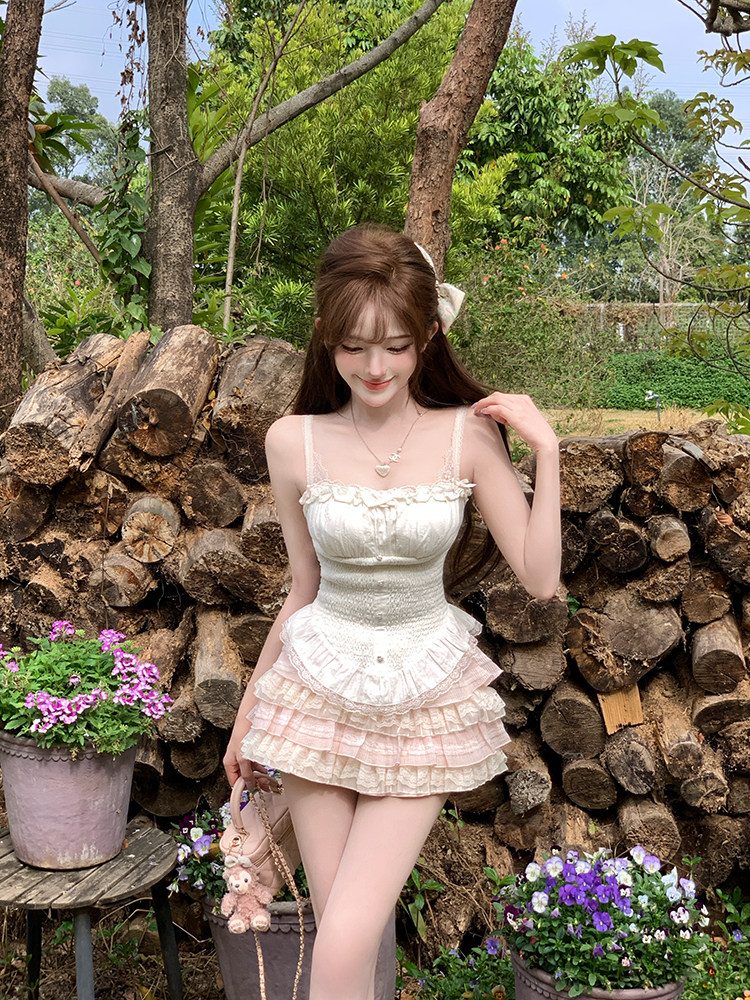 Woman in a white dress standing in front of stacked logs with flowers around