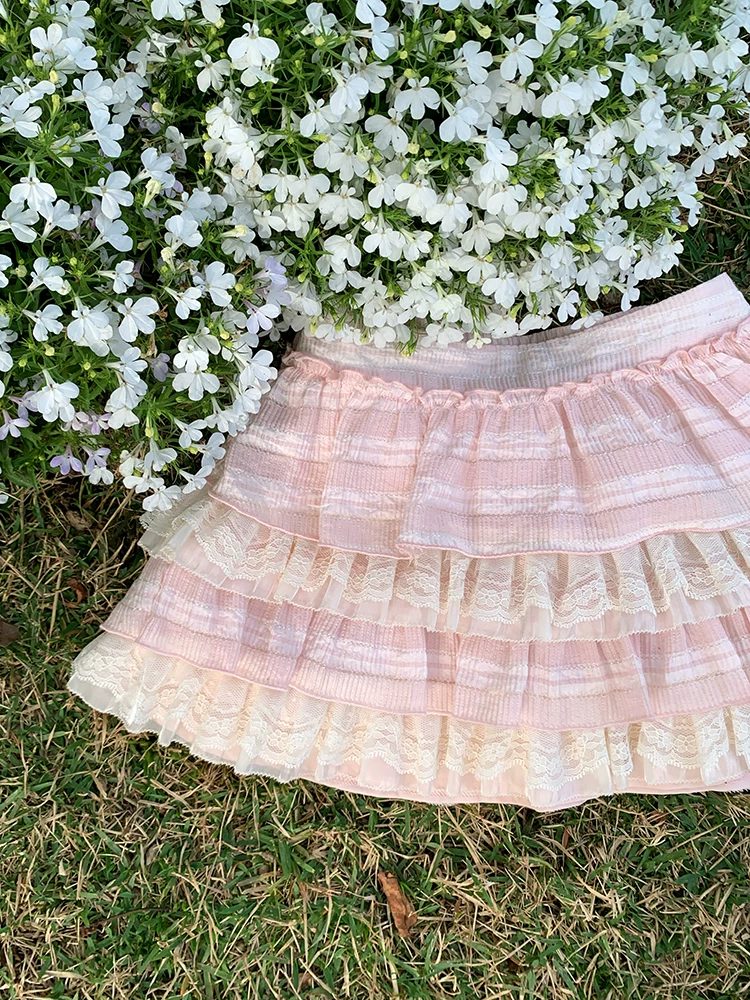 Pink tiered skirt on grass with white flowers in the background