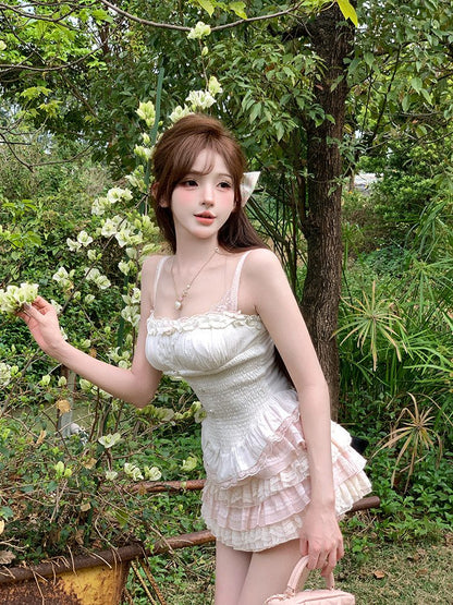 Woman in a white dress standing in a garden with greenery and flowers.
