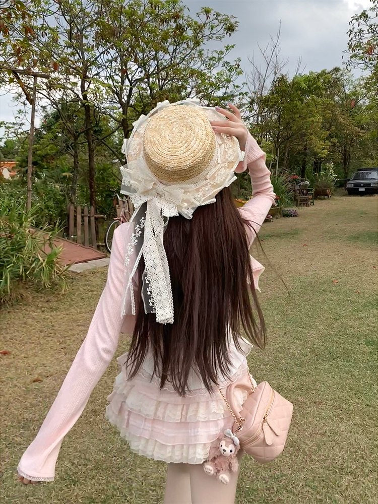 Person wearing a decorative straw hat with lace in an outdoor setting