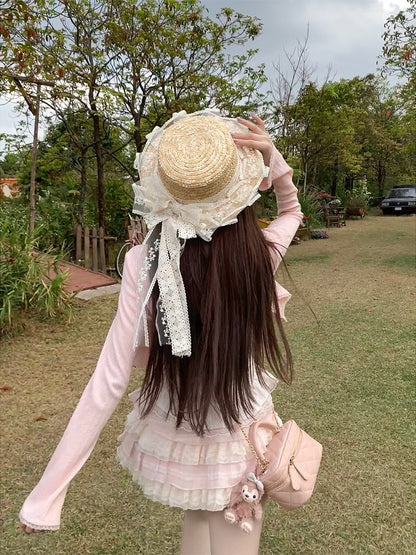 Person wearing a decorative straw hat with lace in an outdoor setting