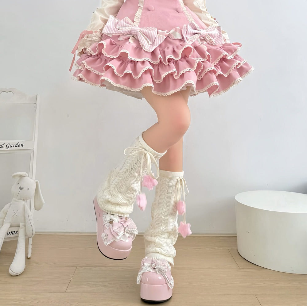 Person wearing a pink skirt, white stockings with pink hearts, and pink shoes in a minimalistic room.