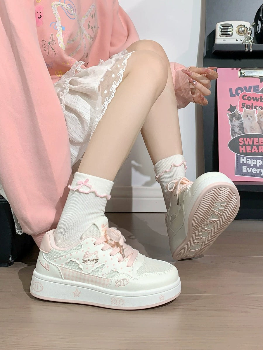 Person wearing light pink sneakers with decorative elements on a wooden floor.