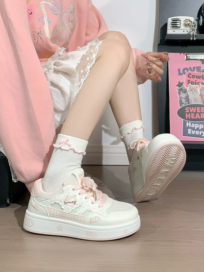 Person wearing light pink sneakers with decorative elements on a wooden floor.