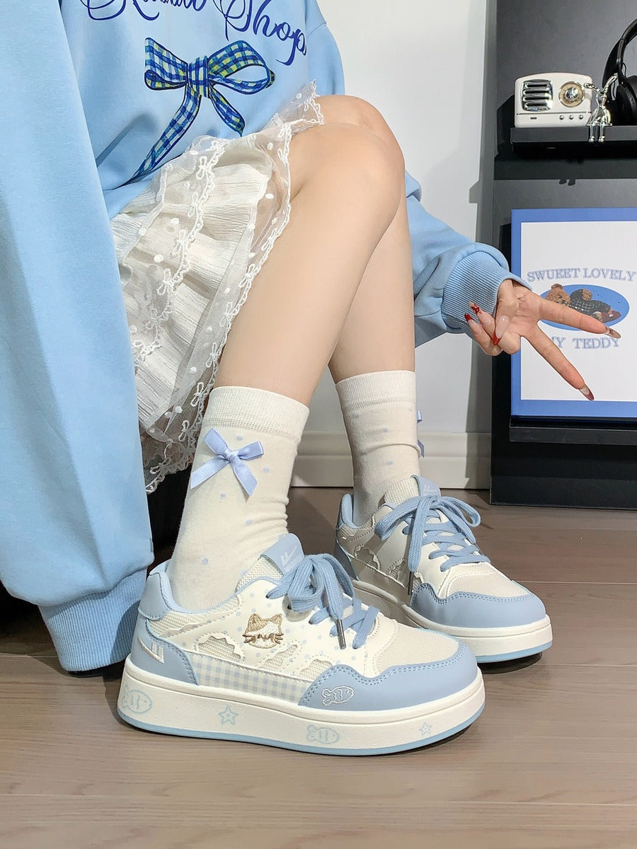 Person wearing light blue and white sneakers with matching socks, sitting on a wooden floor.