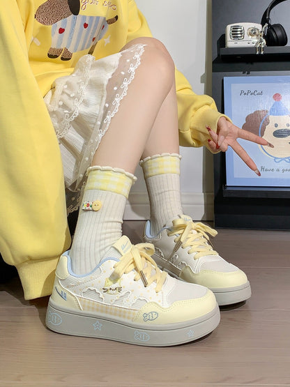 Person wearing yellow sneakers and socks sitting on a chair with a screen displaying a cartoon character in the background.