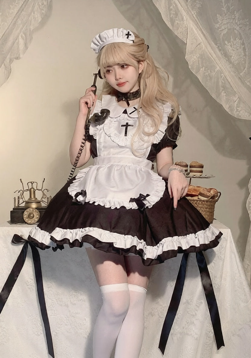 Person wearing a black and white maid outfit with a white hat, sitting on a chair.
