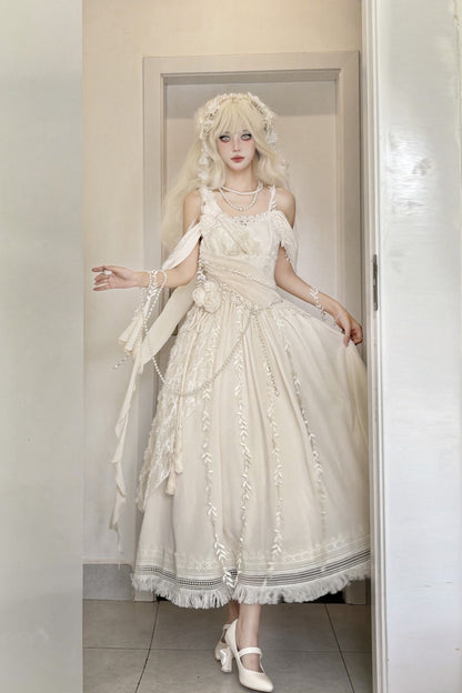 A model wearing a voluminous off-white Lolita-style dress with lace details, a matching headpiece, and white Mary Jane shoes, standing in a doorway.