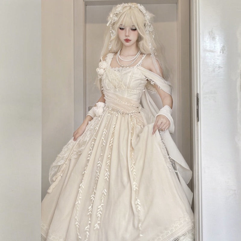 A woman modeling a voluminous off-white Lolita-style dress with lace embroidery, a matching headpiece, and white shoes, standing in a doorway.
