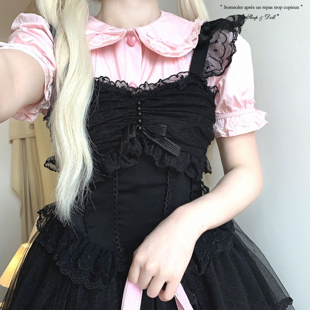 Person wearing a black and pink dress with ruffled details.