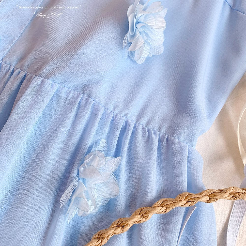 Light blue dress with white floral details and a braided belt on a plain background