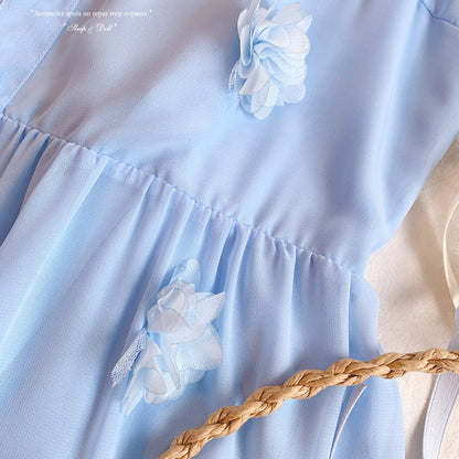 Light blue dress with white floral details and a braided belt on a plain background