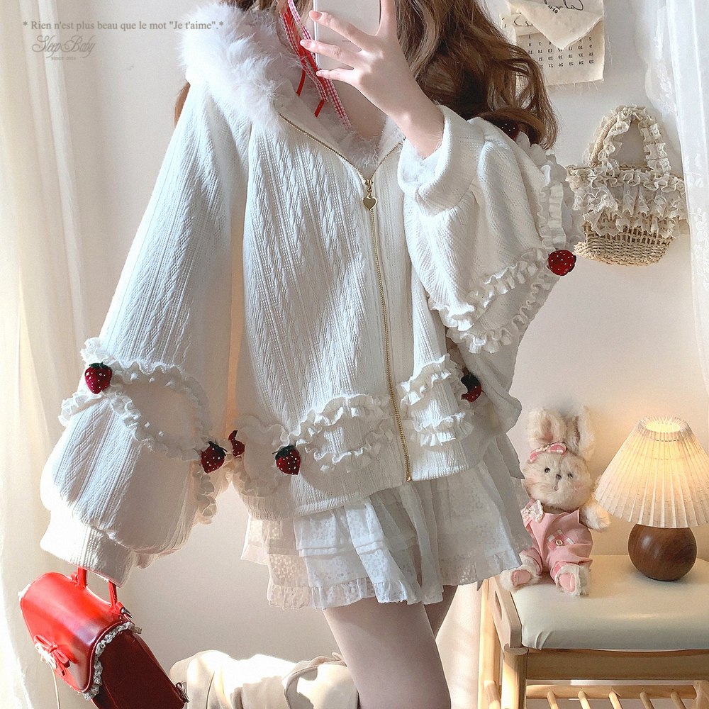 Person wearing a strawberry jacket lace with red accents in a room setting.