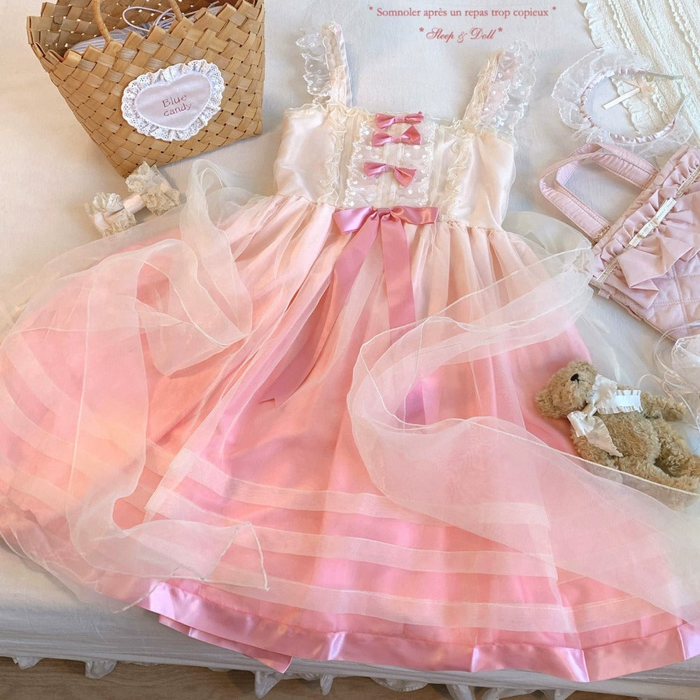Pink dress with white lace details on a light surface, surrounded by decorative items.