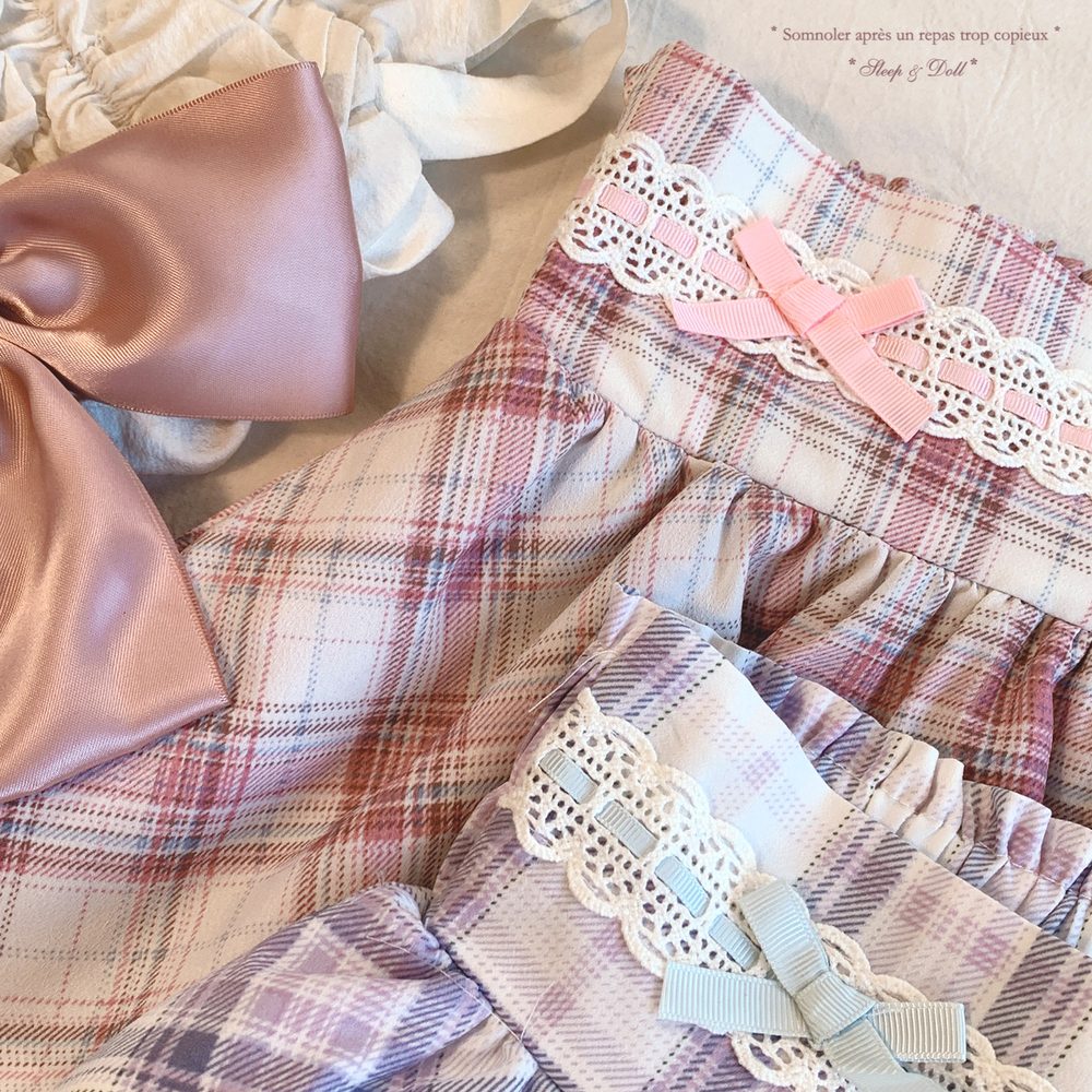 Plaid fabric with lace and ribbon details on a textured surface