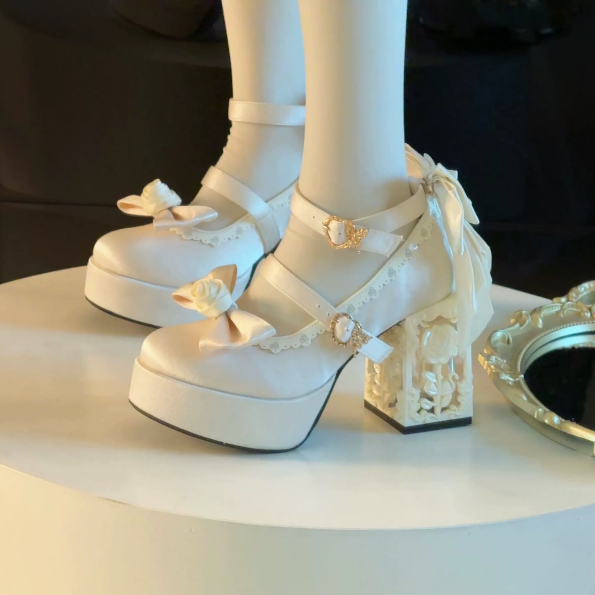 White platform shoes with decorative elements on a white surface.