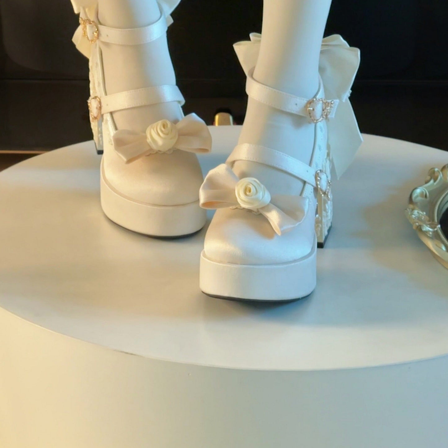 White platform shoes with decorative bows on a white surface