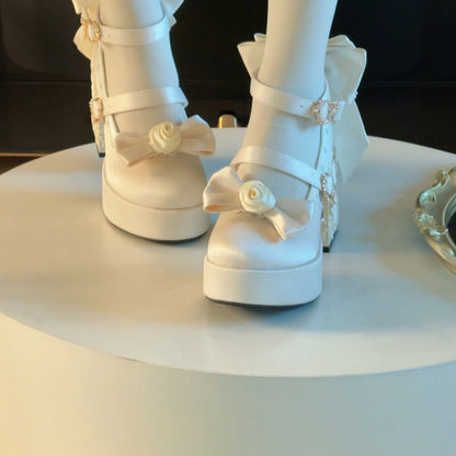 White platform shoes with decorative bows on a white surface