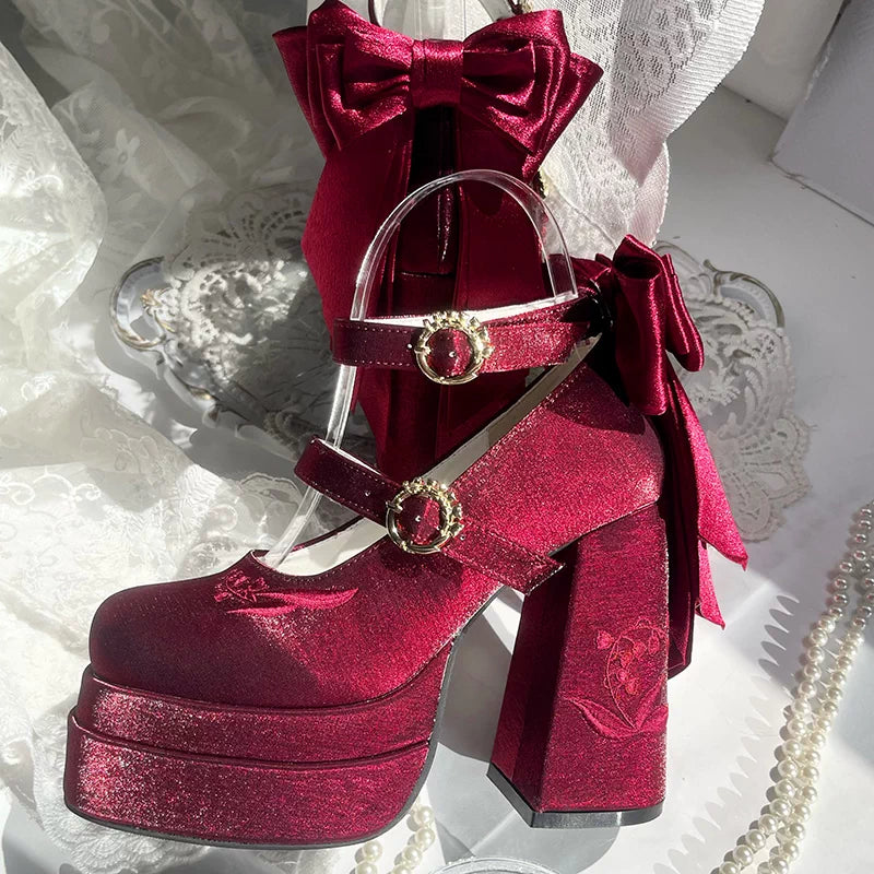Red platform shoe with decorative bows on a white lace background