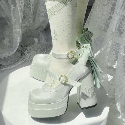 White platform shoes with decorative straps and ribbons on a white background