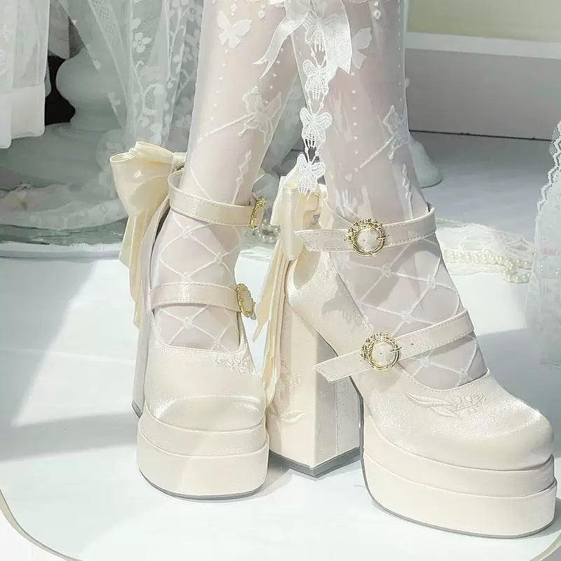White platform shoes with decorative straps and buckles on a white surface.