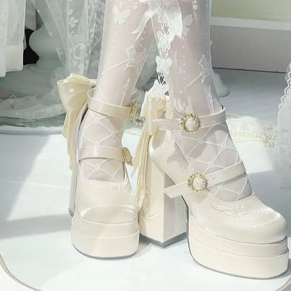 White platform shoes with decorative straps and buckles on a white surface.