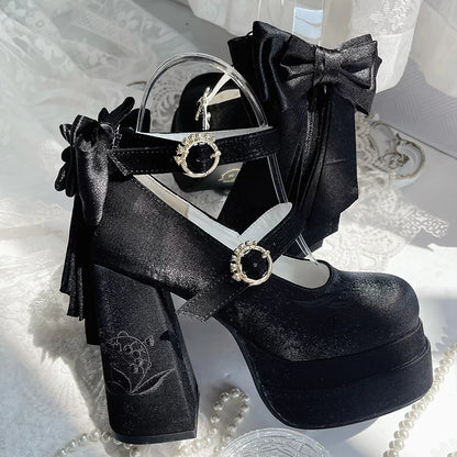 Black platform shoes with decorative bows and straps on a white textured background