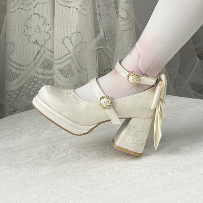 White platform shoes with decorative bow and strap on a white background