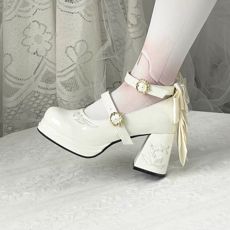 White platform shoes with decorative ribbons and buckles on a white background