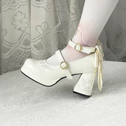 White platform shoes with decorative ribbons and buckles on a white background