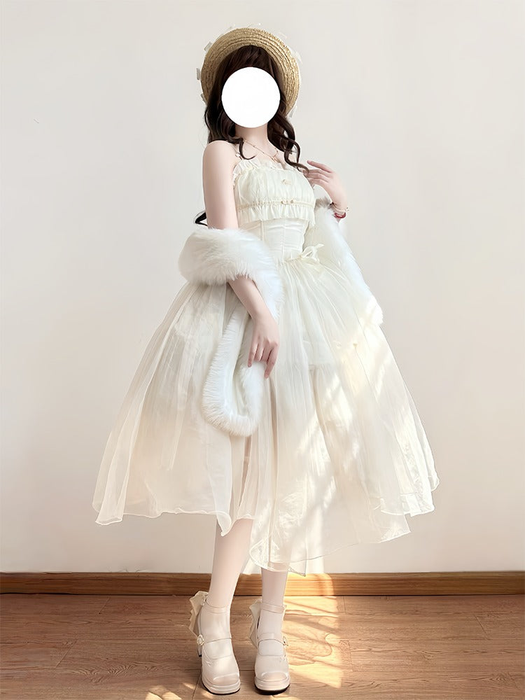 Woman in a white dress with a fur stole and hat against a plain wall.