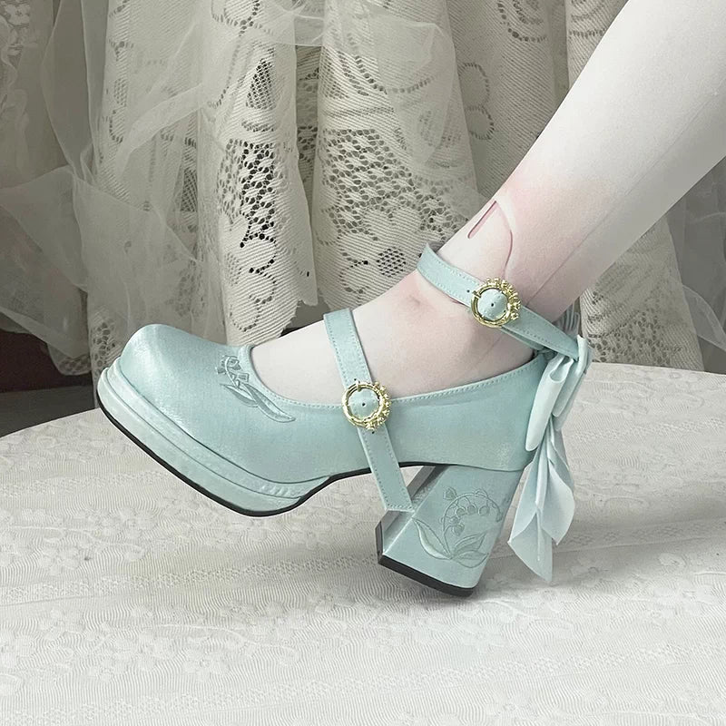 Light blue shoes with decorative straps and bows on a neutral background