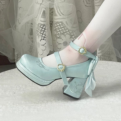 Light blue shoes with decorative straps and bows on a neutral background