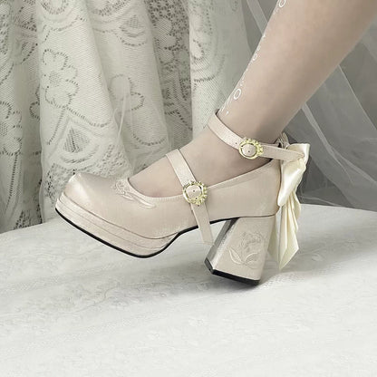 Beige high-heeled shoes with decorative bow and straps on a light background