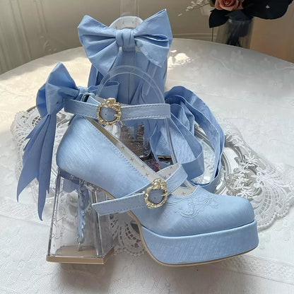 Light blue high-heeled shoes with decorative bows on a white lace tablecloth.