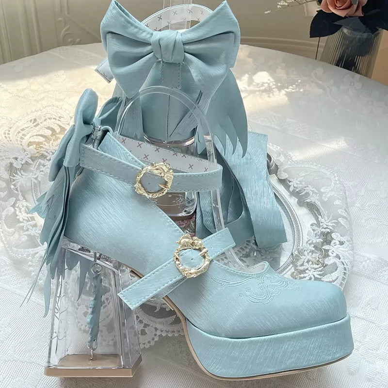 Light blue high-heeled shoes with decorative bows and straps on a white lace tablecloth.